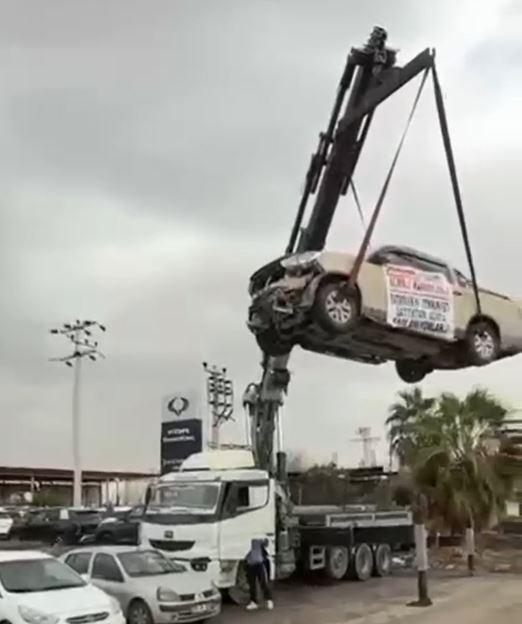 Aldığı sıfır kamyoneti, hatalı çıktığını öne sürüp, bayinin önünde vinçle kaldırarak sergiledi