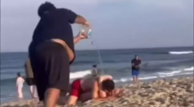A fight broke out among the citizens after they warned a couple displaying overly intimate behavior on the beach.