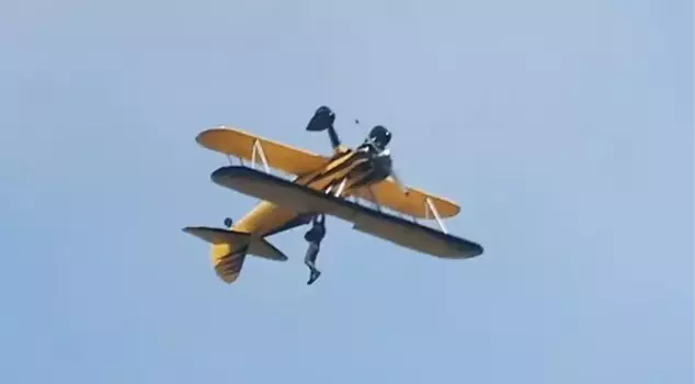 Tom Cruise, known for filming Mission Impossible scenes, performed his latest crazy stunt by hanging from an airplane.