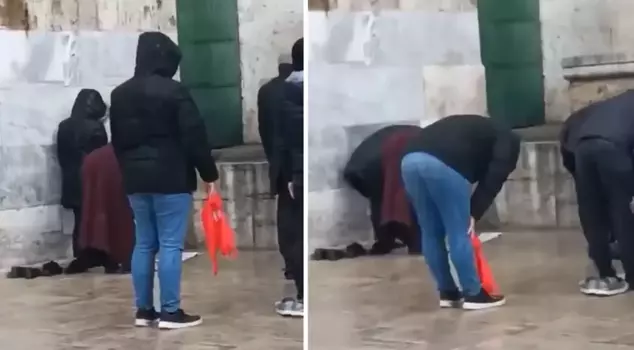 The video of a citizen praying in the rain has divided viewers.