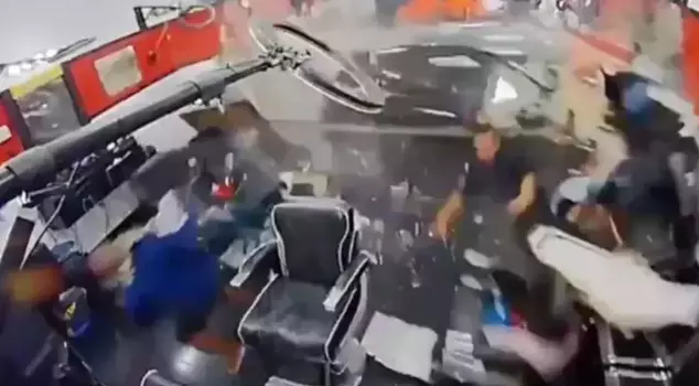 The out-of-control luxury car crashed into the barber shop.