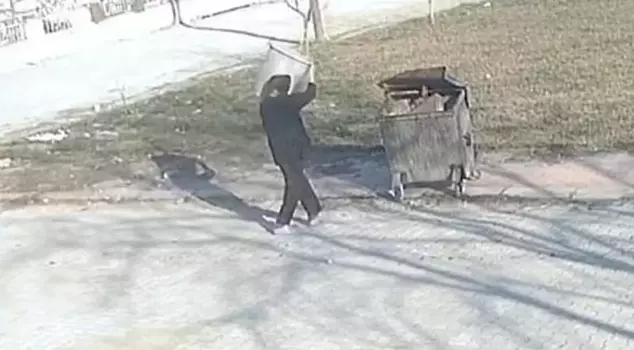 He threw the dog, which he had tied its legs, into the trash container.