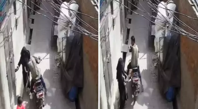 The young man on the motorcycle forcibly kissed the woman he cornered on the street.