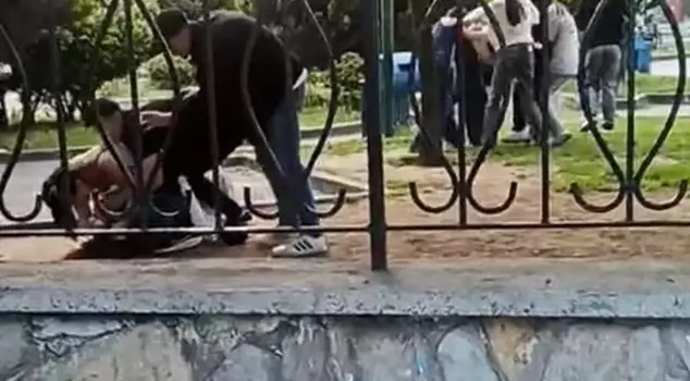 In the park, three groups, including girls, hit each other mercilessly.