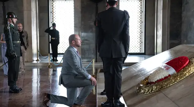 The minister kneeling in front of Atatürk's mausoleum spoke.