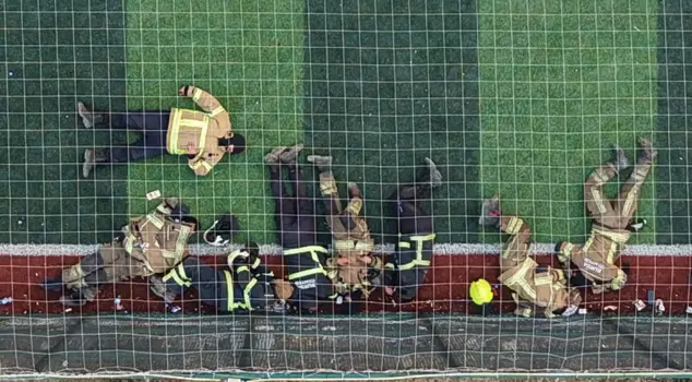Firefighters who battled flames for 12 hours rested like this on the turf field.