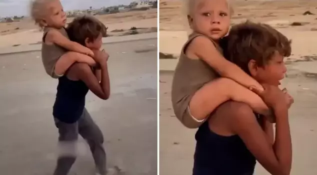 Heartbreaking image from Gaza: Migrating while crying with her brother on her back.