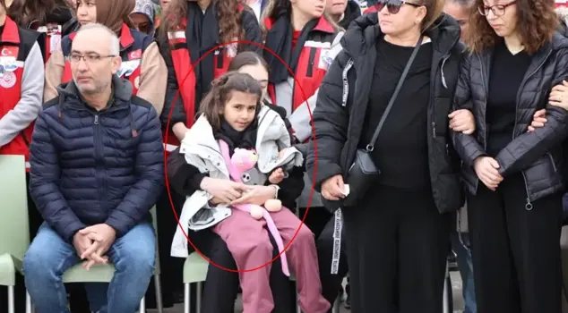 The martyr's child waited by hugging his toy.