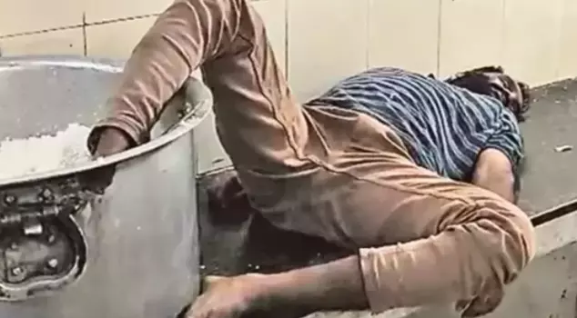 The drunk guard working at the student dormitory was caught sleeping with his foot in a pot of rice.