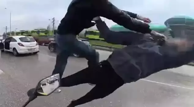 A flying kick fight that rivals movie scenes in traffic captured on camera.