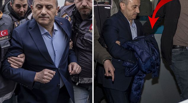 Tuncay Sonel covered his hands with his coat while being taken to prison.