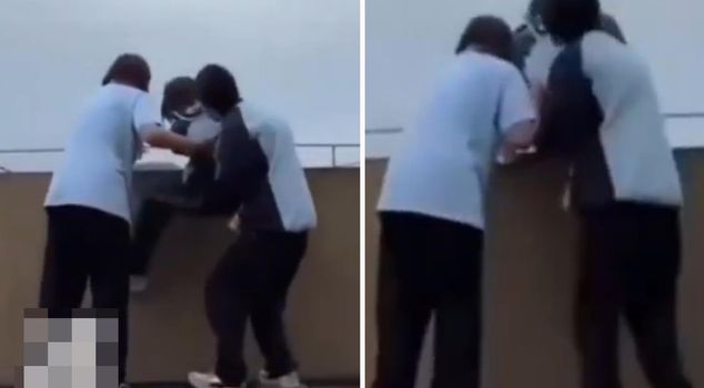 Female students attempted to throw their friend off the roof.