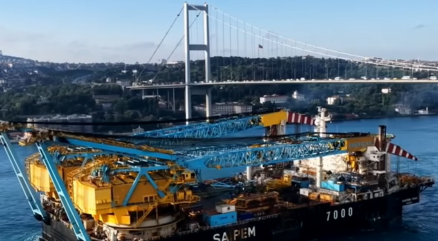 Грузовое судно с краном проходит через Босфор.