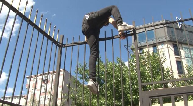 Those who were late for the university entrance exam tried to enter by jumping over the iron railings.