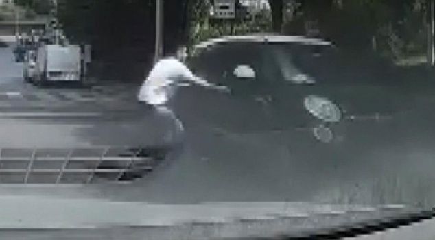 He noticed the car sliding down the slope, got out of his own car, ran over, grabbed its hood, and stopped it.