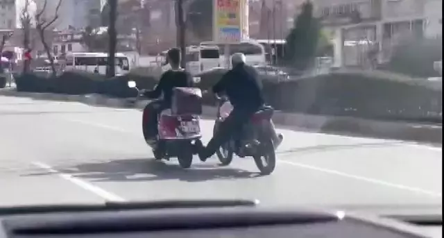 Akan trafikte motosiklet sürücüsü bir diğer motosiklet sürücüsünü ayağıyla itmeye çalıştı