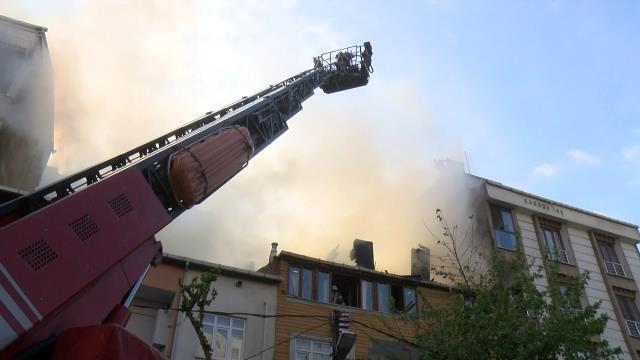 Alev alev yanan çatıya, balkondan bahçe hortumuyla müdahale etmeye çalıştı