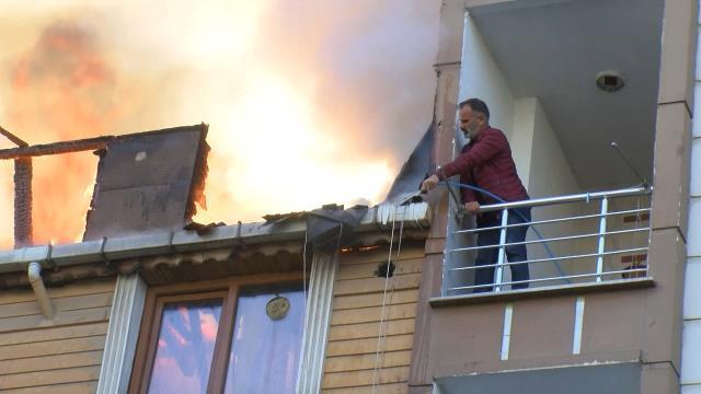 Alev alev yanan çatıya, balkondan bahçe hortumuyla müdahale etmeye çalıştı