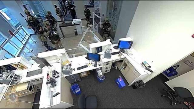 Bankadaki rehineleri kurtarmak için bilgisayar monitörünün içinden ateş edip soyguncuyu alnından vurdu