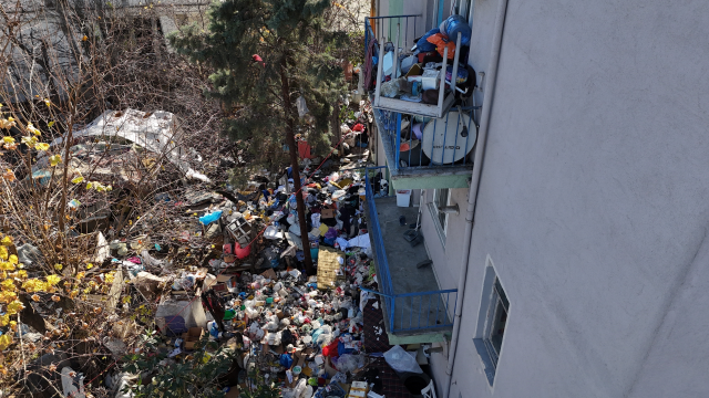 Mahalleli kokudan isyan etti, evden kamyon kamyon çöp çıkarıldı