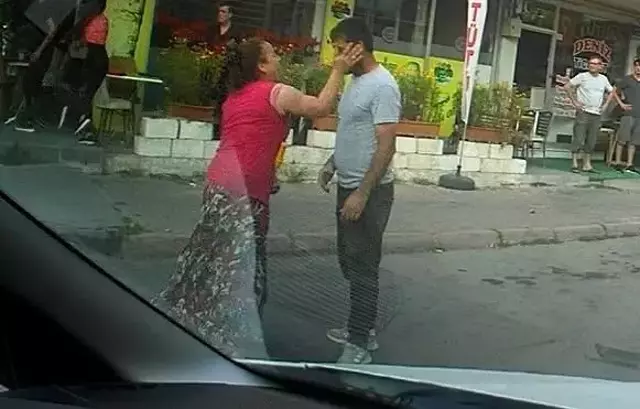 Eli sopalı kadın önüne gelen erkeği dövdü