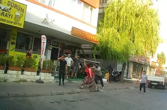 Eli sopalı kadın önüne gelen erkeği dövdü