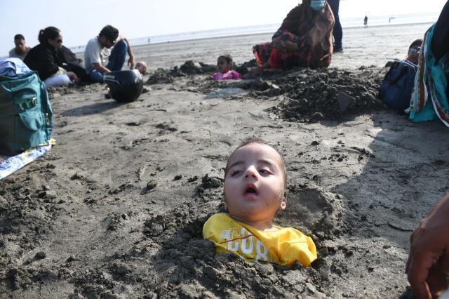 Pakistan'da güneş tutulması sırasında çocuklar iyileşmeleri için kuma gömüldü