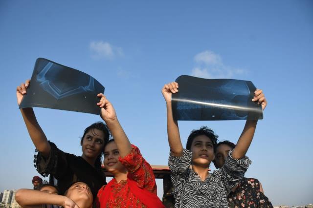 Pakistan'da güneş tutulması sırasında çocuklar iyileşmeleri için kuma gömüldü