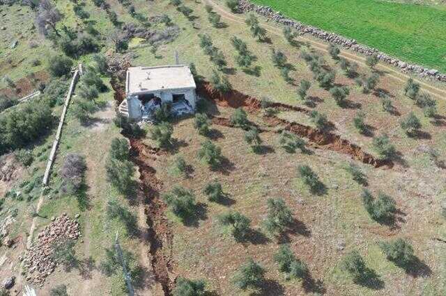 Deprem bölgesindeki bir ev, arazide oluşan yarığa gömüldü