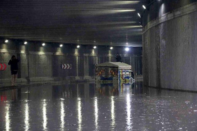 Canlarını kurtarmak için suda mahsur kalan aracın üstüne çıktılar
