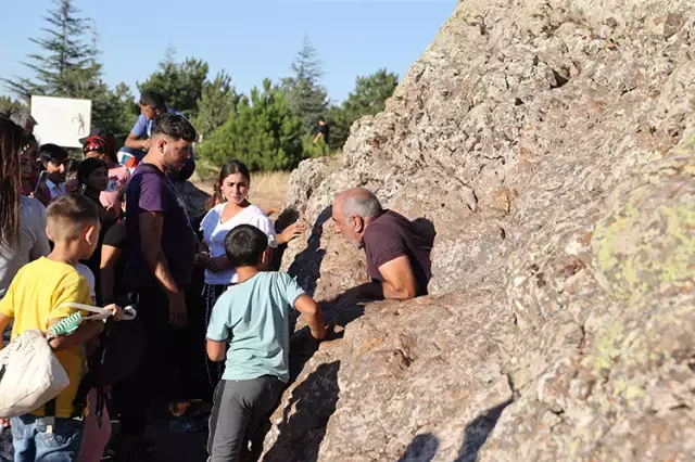 Delikli Taş önünde dua eden ziyaretçiler