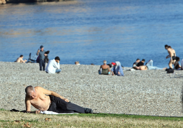 Antalya'da vatandaşlar gündüz güneşlenip, akşam soba yakıyorlar