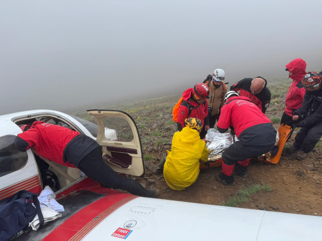Yaralı kadın yolcu, uçağın enkazını bulan ekibe el salladı