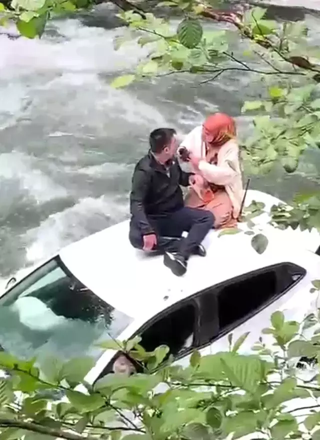 Rize'de dereye uçan aracın üzerine çıkarak yardım beklediler
