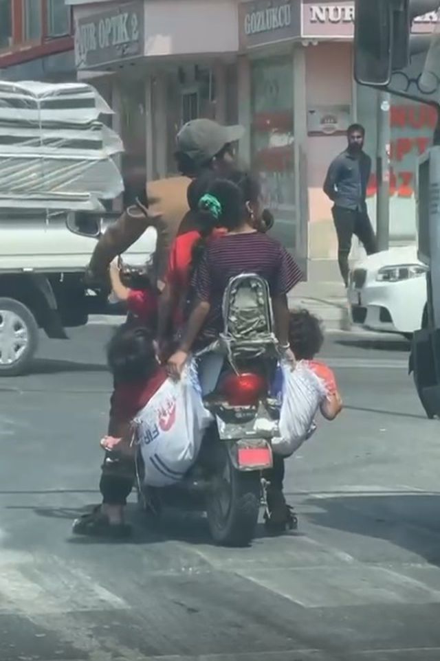 Ölümüne rahatlık! Çocuklarını motosiklete astığı çuvallara koydu