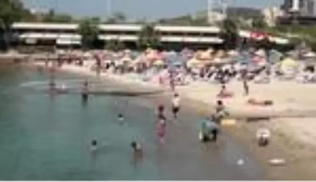 Kuşadası'nda sıcak havadan bunalan soluğu plajda aldı