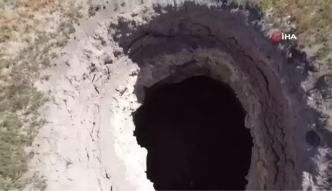 Tarla ortasında oluşan dev obruk köylüleri tedirgin ediyor