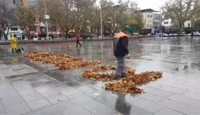 Temizlik işçisi ağaçlardan düşen yapraklarla 