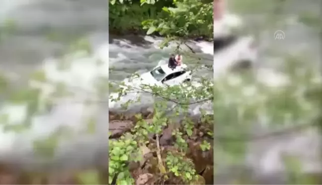 Dereye düşen otomobildeki çift, aracın üzerine çıkarak kurtuldu