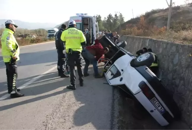 SU KANALINA DEVRİLEN OTOMOBİLDE SIKIŞAN SÜRÜCÜYÜ İTFAİYECİLER KURTARDI