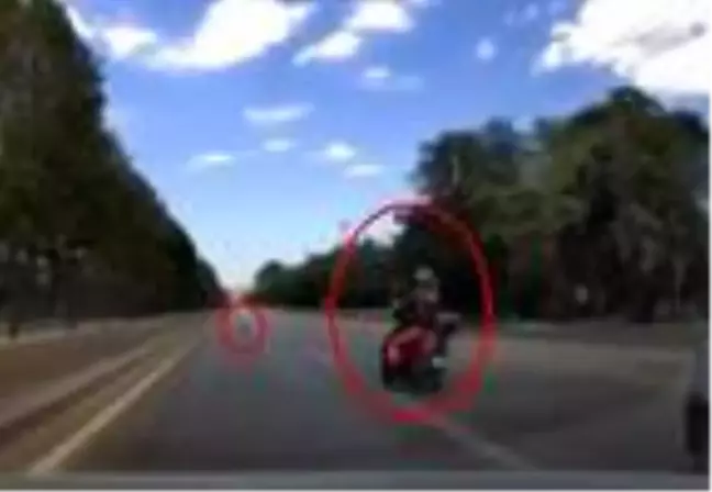 Motosikletlinin seyir halindeyken yerdeki çöpü ayağıyla alma anı kamerada