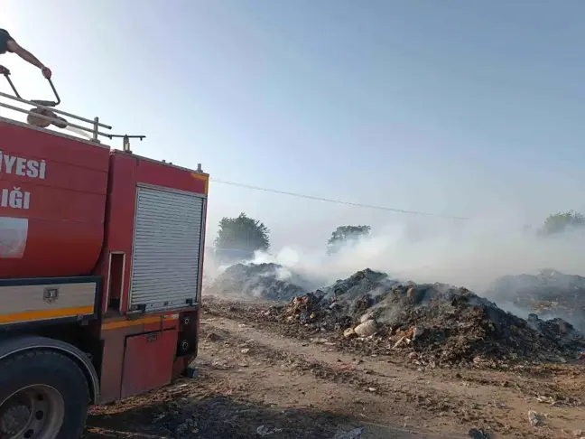 Hatay'ın Kumlu ilçesinde çıkan çöp yangını kepçe yardımıyla söndürüldü