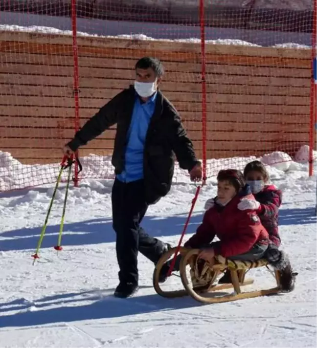 Sağlıkçılar için düzenlenen kayak kursunda engelli oğluna kızak keyfi yaşattı