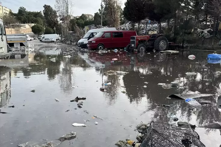 İzmir Buca'da şantiyedeki çöpler yağmur sularıyla yola dağıldı