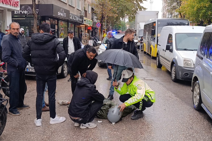 In İnegöl, a female police officer held an umbrella over an injured person lying on the ground in the rain! She did not leave the injured person's side until the ambulance arrived.