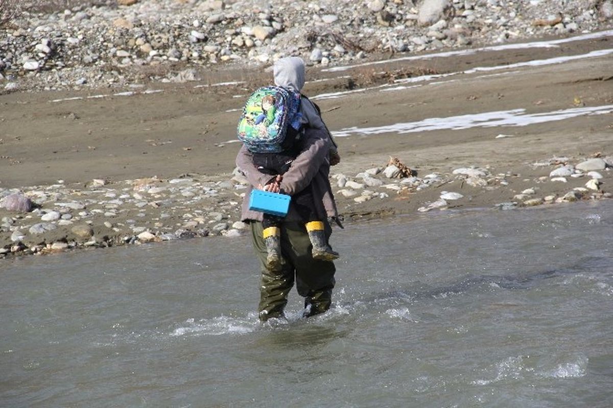 Okula Geç Kalmamaları İçin Çocuklarını Sırtında Taşıyarak Çaydan Geçiyor