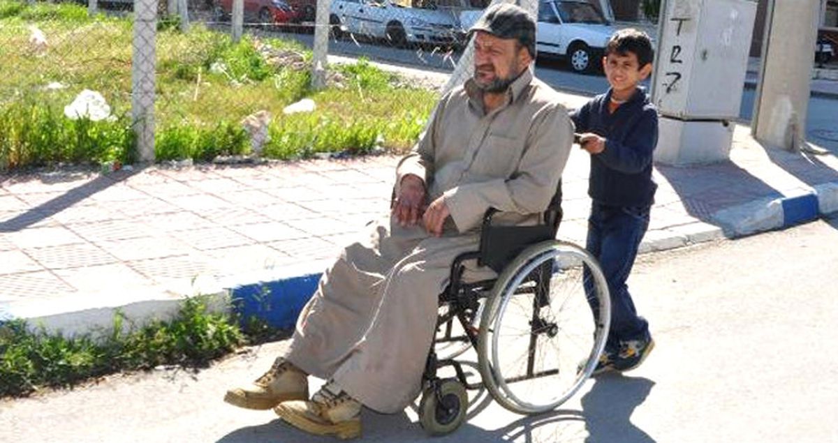 Iraklı Çocuk, Tekerlekli Sandalyedeki Engelli Babasını Gezdiriyor