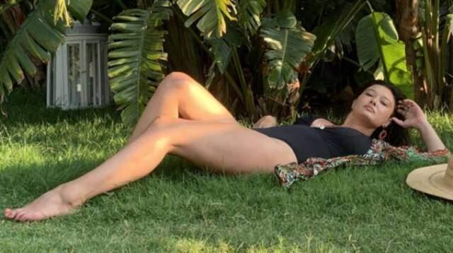 Nurgül Yeşilçay, siyah mayosuyla çimlere uzanarak poz verdi
