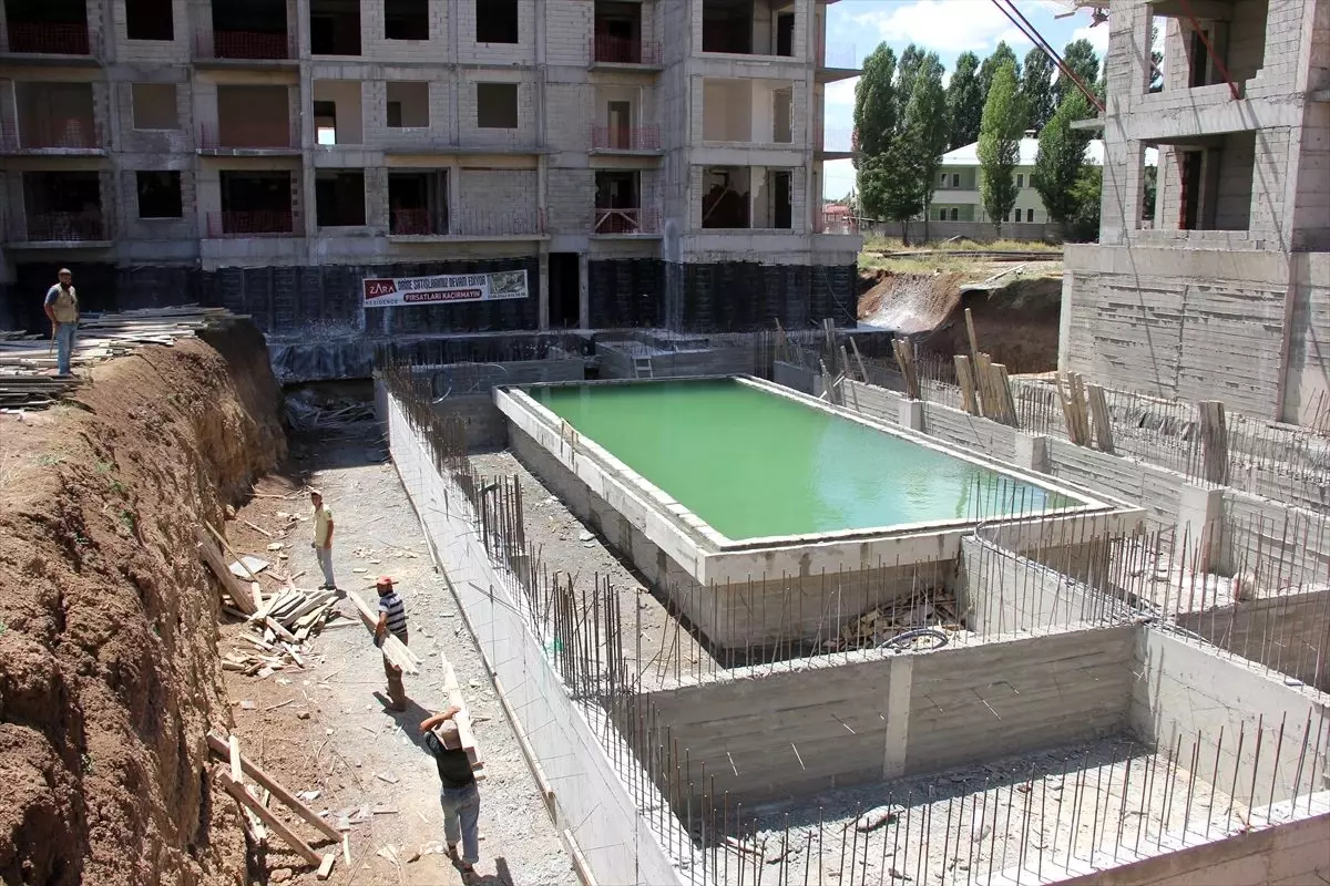 Sıcaktan bunalan işçiler havuz inşaatında serinliyor