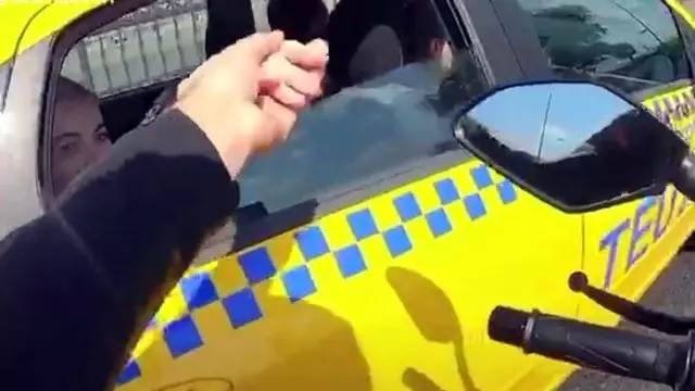 Motosiklet sürücüsü, yollarda taksideki kadının elini tuttu